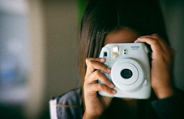 Mädchen mit Polaroid-Kamera