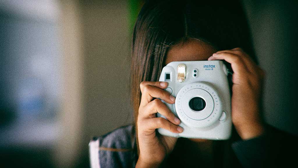 Mädchen mit Polaroid-Kamera
